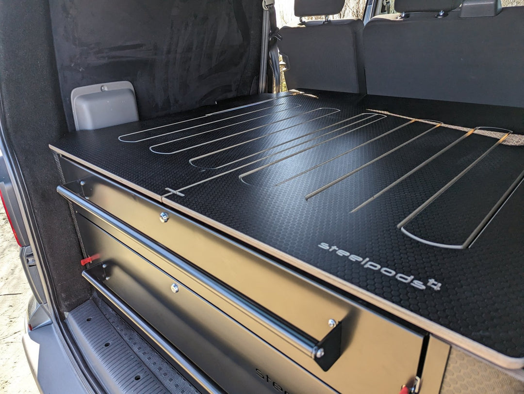A sliding bed in a van made from black hexa board, to create a day-van experience